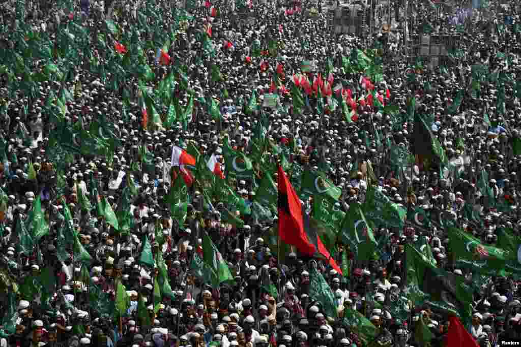 Supporters of the Grand Democratic Alliance (GDA), an alliance of political parties, carry flags as they gather for a sit-in protest against what they call election rigging and are demanding free and fair results of the general elections, along the main Highway in Jamshoro, Pakistan.