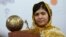 FILE- In this Sept. 6, 2013, image, Malala Yousafzai, who was shot and injured by the Taliban for advocating for girls' education, poses for photographers after being awarded the International Children's Peace Prize 2013.