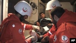 Lebanese medics treat an injured Syrian man before taking him to a hospital after he crossed from the Syrian town of Talkalakh into the northern border area of Wadi Khaled, Lebanon, May 14, 2011