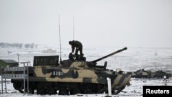 A Russian service member stands on a BMP-3 infantry fighting vehicle during drills held by the armed forces of the Southern Military District at the Kadamovsky range in the Rostov region, Russia Jan. 27, 2022.