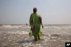 FILE - In this April 13, 2017 photo, Elizabeth Brenner, who is following the last footsteps of her son in India, enters the Gangasagar beach in West Bengal state, where the Ganges river flows into the Bay of Bengal. Brenner's son Thomas Plotkin died during a study-abroad trip to the mountains of India more than five years ago. His body was never found. Brenner spent two months tracing the 1,037 mile path along the Ganges River as she believes this is the path taken by her son's remains.