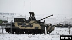 A Russian service member stands on a BMP-3 infantry fighting vehicle during drills held by the armed forces of the Southern Military District at the Kadamovsky range in the Rostov region, Russia Jan. 27, 2022.