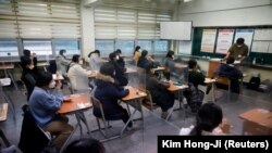 Siswa menunggu dimulainya ujian masuk perguruan tinggi tahunan di tengah pandemi Covid-19 di aula ujian di Seoul, Korea Selatan, 3 Desember 2020. (Foto: REUTERS/Kim Hong-Ji)
