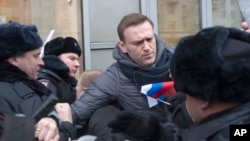 FILE - Russian opposition leader Alexei Navalny, center, is detained by police officers in Moscow, Jan. 28, 2018.