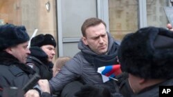 FILE - Russian opposition leader Alexei Navalny (C) is detained by police officers in Moscow, Jan. 28, 2018. 