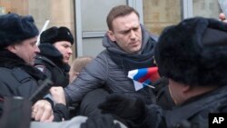 FILE - Russian opposition leader Alexei Navalny (C) is detained by police officers in Moscow, Jan. 28, 2018. 