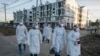 ရန်ကုန်မြို့ Quarantine Center တခုအပြင်ဘက်တွင်တွေ့ရသည့် PPE ဝတ်စုံဝတ် ပရဟိတလုပ်သားများ။ (အောက်တိုဘာ ၁၂၊ ၂၀၂၀)