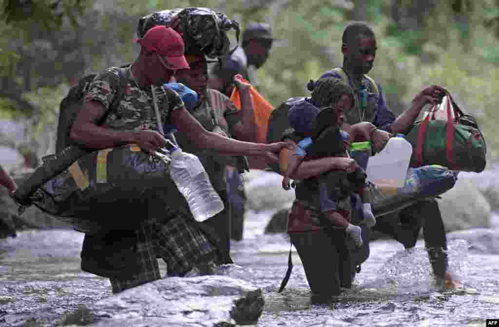 Haitian migrants cross the Darien Gap, near Acandi, Choco department, Colombia, on their way to Panama, Sept, 26, 2021, while trying to reach the United States.