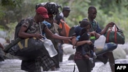 FILE - Haitian migrants cross the jungle of the Darien Gap, near Acandi, Choco department, Colombia, heading to Panama, on Sept. 26, 2021, on their way toward the United States.