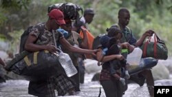 FILE - Haitian migrants cross the jungle of the Darien Gap, near Acandi, Choco department, Colombia, heading to Panama, on Sept. 26, 2021, on their way toward the United States.