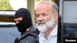 FILE - Joao Vaccari, treasurer of Brazil's ruling Workers' Party, is escorted by police after his arrival in Curitiba, April 15, 2015. 