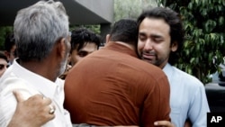 People comfort Musa Gilani, right, the brother of Ali Haider Gilani who has been kidnapped in Multan, Pakistan, May 9, 2013.