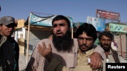 Relatives of police cadets wait for word outside the Police Training Center after an attack on the center in Quetta, Pakistan Oct. 25, 2016.