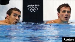 Perenang Amerika Michael Phelps (kiri) dan Ryan Lochte mengamati papan penilaian sesaat setelah menyelesaikan pertandingan 200 meter medley perorangan Olimpiade London 2012 di Aquatics Centre (1/8).