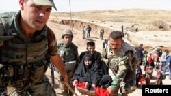 Kurdish Peshmerga forces help people, who fled from their homes in Hawija, in southwest of Kirkuk, Iraq October 4, 2017. 