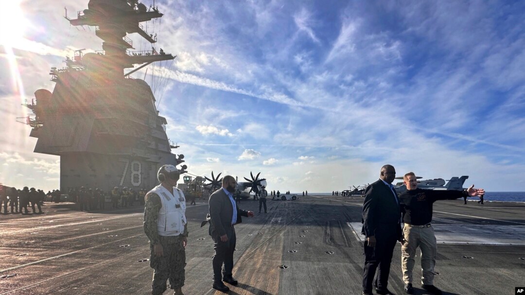 Bộ trưởng Quốc phòng Hoa Kỳ Lloyd Austin (thứ hai, bên phải) nói chuyện với chỉ huy của USS Gerald R. Ford, Đại úy Hải quân Rick Burgess (phải) trong chuyến thăm không báo trước tới con tàu vào ngày 20 tháng 12 năm 2023.