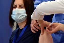 A woman receives the AstraZeneca vaccine under the COVAX scheme against the coronavirus disease in Pristina, Kosovo, March 29, 2021.