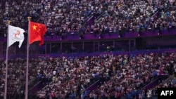 The Olympic Council of Asia flag, left, and China's national flag fly during the opening ceremony of the Asian Games at the Hangzhou Olympic Sports Centre Stadium in Hangzhou in China's eastern Zhejiang province on Sept. 23, 2023.