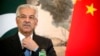 FILE - Pakistan's Foreign Minister Khawaja Muhammad Asif adjusts his necktie during a joint press conference at the Diaoyutai State Guesthouse in Beijing, Sept. 8, 2017.