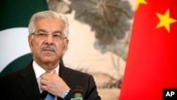 Pakistan's Foreign Minister Khawaja Muhammad Asif adjusts his necktie during a joint press conference at the Diaoyutai State Guesthouse in Beijing, Sept. 8, 2017.