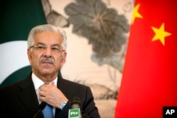 Pakistan's Foreign Minister Khawaja Muhammad Asif adjusts his necktie during a joint press conference at the Diaoyutai State Guesthouse in Beijing, Sept. 8, 2017.