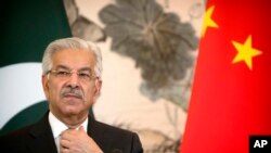 Menteri Luar Negeri Pakistan, Khawaja Muhammad Asif adjusts his necktie during a joint press conference at the Diaoyutai State Guesthouse in Beijing, Sept. 8, 2017.