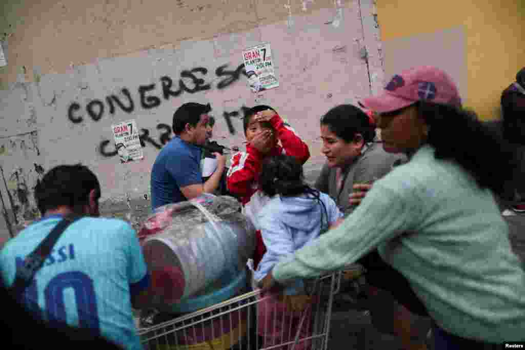 Personas afectadas por los gases lacrimógenos intentan recuperarse mientras los manifestantes participan en una protesta exigiendo elecciones presidenciales y el cierre del Congreso luego de que Pedro Castillo fuera detenido en una prisión policial luego de su destitución, en Lima, Perú, el 8 de diciembre de 2022. REUTERS/Sebastián Castañeda&nbsp;