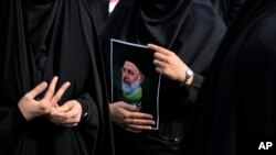 Іранська жінка тримає фотографію президента Ебрагіма Раїсі під час траурної церемонії у Тегерані, 20 травня 2024 року. (Фото: AP Photo/Вахід Салемі)