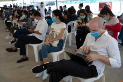 Tourists practice social distancing as they wait to extend their visa at Immigration Bureau in Bangkok, Thailand, March 27, 2020.