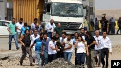 2016年8月15日人们在土耳其东南的吉兹瑞市警察哨所发生汽车炸弹爆炸后抬着一具尸体。