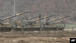 South Korean army soldiers stand on their K-55 self-propelled howitzers during an annual exercise in Paju, near the border with North Korea, Monday, March 7, 2016.