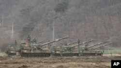 South Korean army soldiers stand on their K-55 self-propelled howitzers during an annual exercise in Paju, near the border with North Korea, Monday, March 7, 2016.