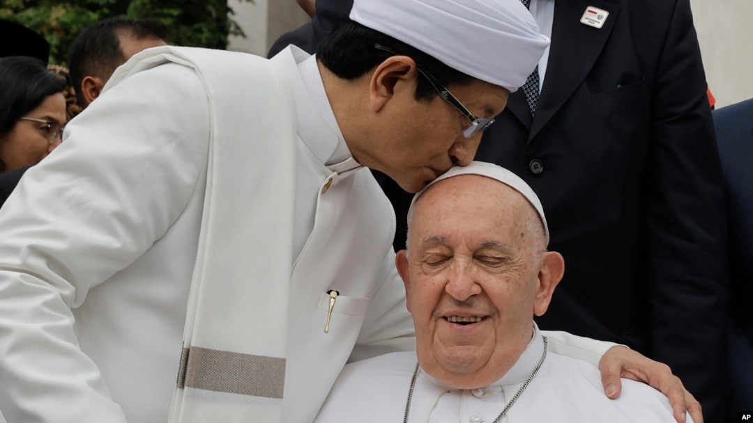 FILE - The Grand Imam of Istiqlal Mosque Nasaruddin Umar, left, hugs Pope Francis during a family photo following an interreligious meeting with religious leaders at the Istiqlal Mosque in Jakarta, Sept. 5, 2024. 
