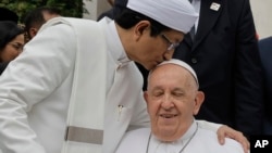 FILE - The Grand Imam of Istiqlal Mosque Nasaruddin Umar, left, hugs Pope Francis during a family photo following an interreligious meeting with religious leaders at the Istiqlal Mosque in Jakarta, Sept. 5, 2024. 