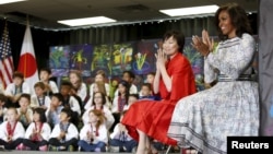 U.S. First Lady Michelle Obama (R) and Akie Abe, wife of Japanese Prime Minister Shinzo Abe, visit Great Falls Elementary School in Great Falls, Virginia, April 28, 2015.