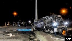 People carry away the injured from the scene of a minibus crash in Igdir, eastern Turkey, March 30, 2018, as the bodies of others lie in the road. 