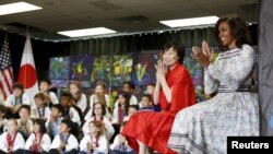 U.S. First Lady Michelle Obama (R) and Akie Abe, wife of Japanese Prime Minister Shinzo Abe, visit Great Falls Elementary School in Great Falls, Virginia, April 28, 2015.