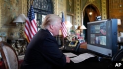 President Donald Trump speaks with members of the armed forces via video conference at his private club, Mar-a-Lago, on Thanksgiving, Nov. 23, 2017, in Palm Beach, Florida.