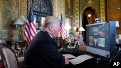 President Donald Trump speaks with members of the armed forces via video conference at his private club, Mar-a-Lago, on Thanksgiving, Nov. 23, 2017, in Palm Beach, Fla.