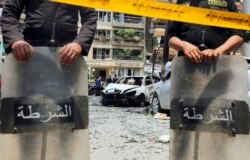 FILE - Policemen investigate the site of a car bomb attack on the convoy of Egyptian public prosecutor Hisham Barakat near his house at Heliopolis district in Cairo, Egypt, June 29, 2015.