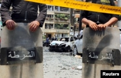 FILE - Policemen investigate the site of a car bomb attack on the convoy of Egyptian public prosecutor Hisham Barakat near his house at Heliopolis district in Cairo, Egypt, June 29, 2015.