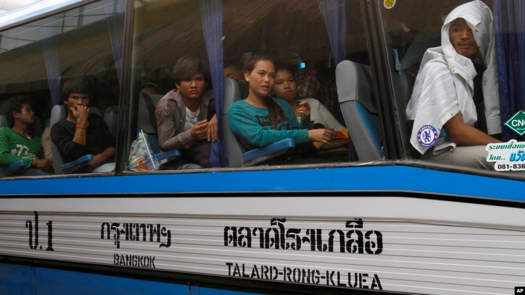FILE PHOTO - Cambodian migrant workers sit in a bus upon arrival at Cambodia-Thailand's international border gate in Poipet, Cambodia, from Thailand, Tuesday, June 17, 2014.