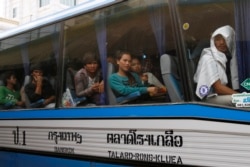 FILE PHOTO - Cambodian migrant workers sit in a bus upon arrival at Cambodia-Thailand's international border gate in Poipet, Cambodia.