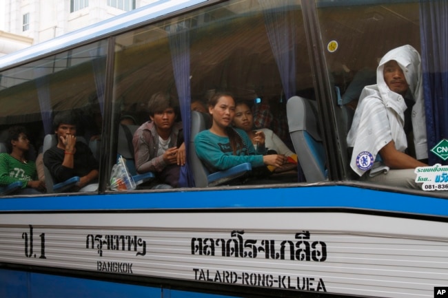 FILE PHOTO - Cambodian migrant workers sit in a bus upon arrival at Cambodia-Thailand's international border gate in Poipet, Cambodia.