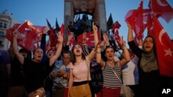 Warga Turki memberikan dukungan terhadap pemerintahan Erdogan pada aksi unjuk rasa di Lapangan Taksim, Istanbul, Sabtu (16/7). 