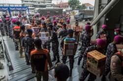 Para anggota TNI Angkatan Laut memuat bantuan untuk korban Siklon Tropis Seroja ke KRI Semarang di Pelabuhan Dermaga, Surabaya, Sabtu, 10 April 2021. (Foto: Juni Kriswanto/AFP)