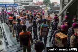 Para anggota TNI Angkatan Laut memuat bantuan untuk korban Siklon Tropis Seroja ke KRI Semarang di Pelabuhan Dermaga, Surabaya, Sabtu, 10 April 2021. (Foto: Juni Kriswanto/AFP)