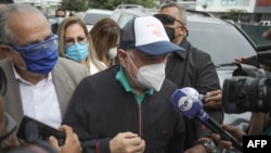 Mantan presiden Panama Ricardo Martinelli dikelilingi oleh wartawan setibanya di kantor Kejaksaan di Panama City, pada 2 Juli 2020 di tengah pandemi Covid-19.