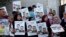 FILE - Palestinian demonstrators hold pictures of detainees as they take part in a protest in solidarity with Palestinian prisoners held in Israeli jails, in front of the United Nations headquarters in the West Bank city of Ramallah.