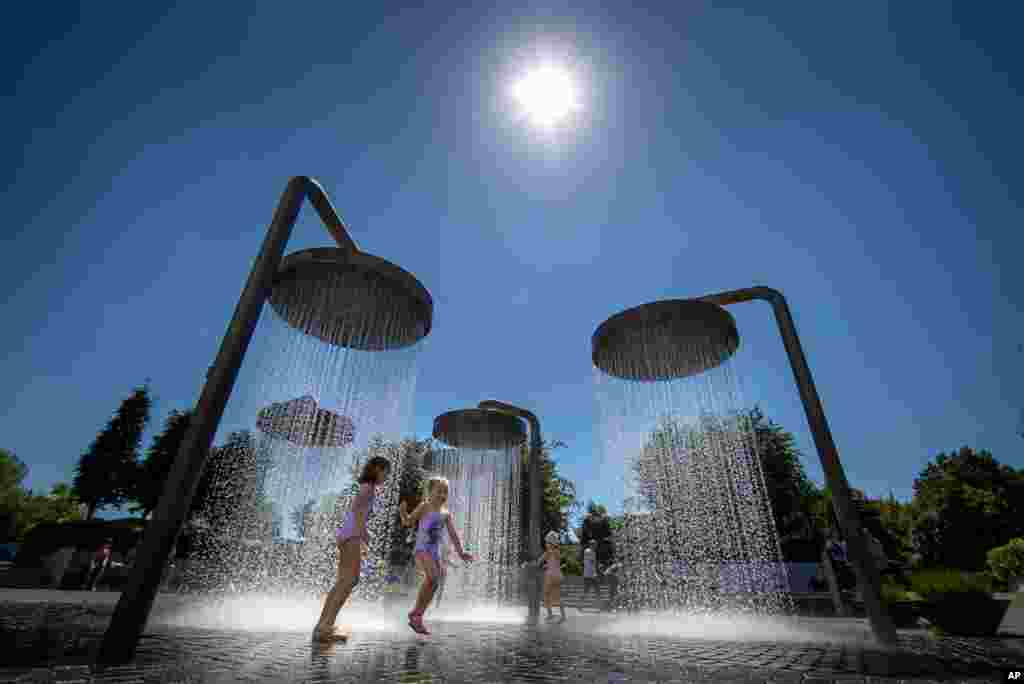 Children cool off in a public fountain in Vilnius, Lithuania, June 19, 2021.
